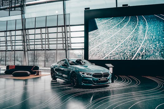 Elegant luxury coupe showcased in a modern Munich auto showroom with glass architecture.